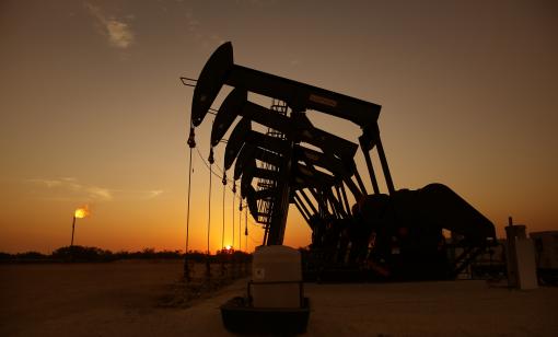 The sun sets behind six pumpjacks producing on a wellpad outside Cotulla, Texas. (Photo by Tom Fox, courtesy of Oil and Gas Investor)